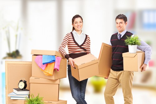 Movers using safe manual handling techniques with equipment