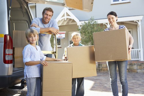 Movers loading boxes and furniture into a removals vehicle