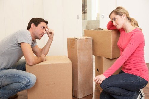 Packed moving boxes and furniture ready for transport in Maidavale